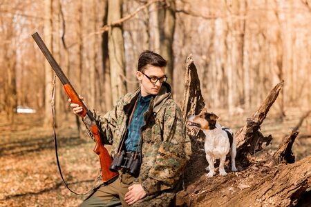 Portrait of a yang hunter with a dog on the forest.の写真素材