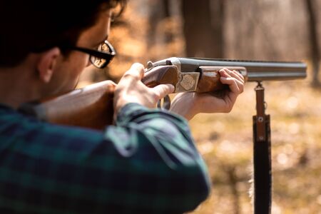 Autumn hunting season. Man hunter with a gun. Hunting in the woods.の写真素材