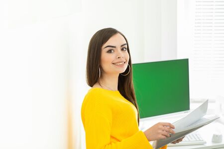 Woman in a yellow sweater working from home during Coronavirus quarantine. Health care. Staying at home.の写真素材