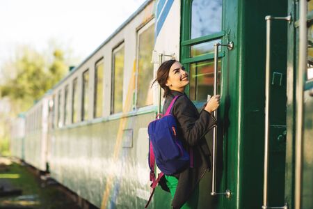 Young beautiful woman with backpack go to travel by train at the train station. Travel and lifestyle concept.の写真素材