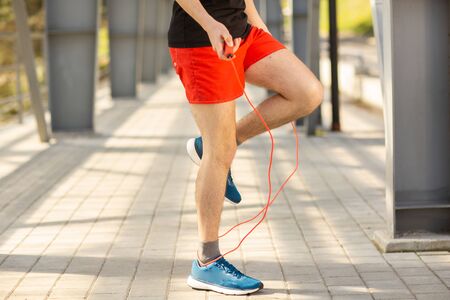 Close up of male legs skipping with jump rope outdoors. Exercising and lifestyle concept.の写真素材