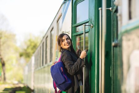 Young beautiful woman with backpack go to travel by train at the train station. Travel and lifestyle concept.の写真素材