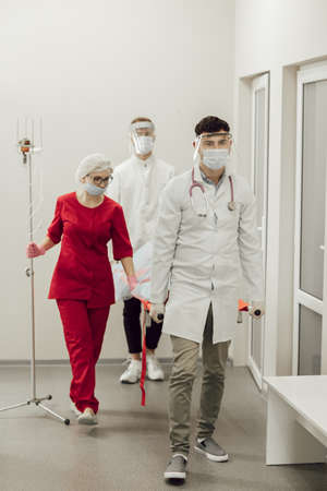 Ambulance doctors brought a patient with a coronavirus patient on a stretcher. Doctors in protective suits take the patient to the hospital. Coronavirus pandemic, pneumoniaの写真素材