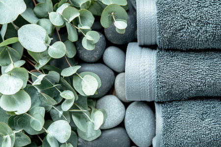 Close-up of rolled towels with spa stones and fresh eucalyptus leavesの写真素材