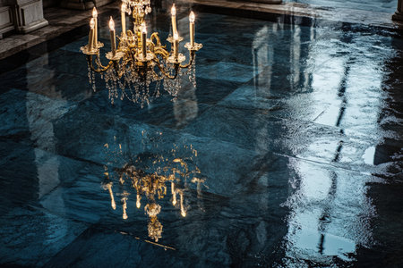 Water from a recent rainfall has pooled on the floor reflecting the intricate design of a chandelier...