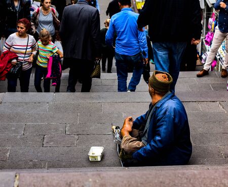 A handicapped beggar sitting on the road