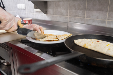 Cooking process of quesadilla with pans and a cookの写真素材