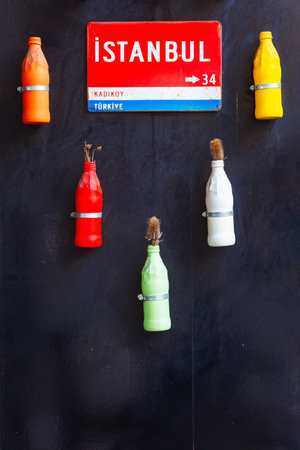 vases in the shape of colored glass bottles on the wallの写真素材