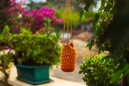 garden lantern wicker made of ropes and glass jar suspended in the garden