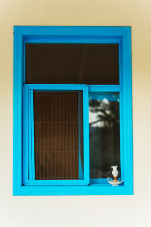 A beautifully designed blue window featuring a lamp on the window sillの写真素材