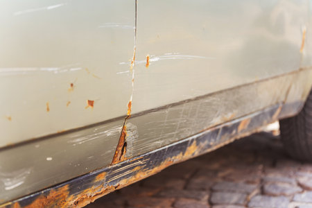 Closeup of a rusty car with a yellow light on its sideの写真素材