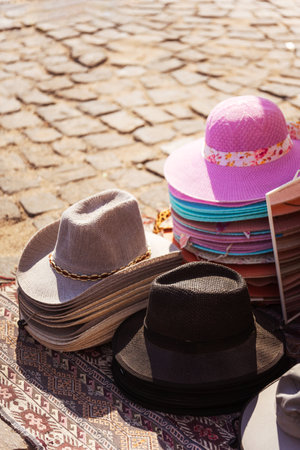 A large collection of hats is neatly stacked on top of each other