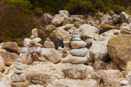 Zen stones neatly arranged stack of rocks surrounded by trees in the backgroundの写真素材