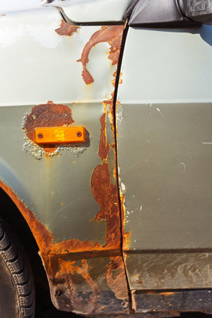 Closeup of a rusty car with a yellow light on its sideの写真素材