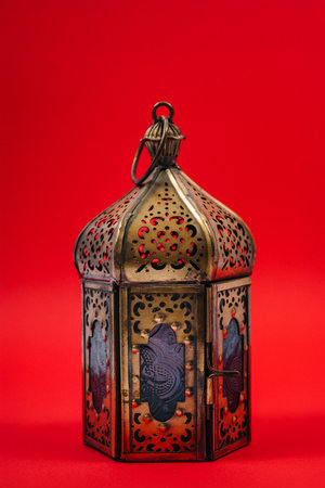 An oriental-style iron candlestick on a red background. metal candelabrum for lighting candlesの写真素材