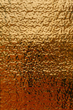 stamped gold-colored iron sheet. textured tin sheet on the wallの写真素材