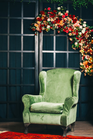 green armchair against of a black lattice decorated with flowers. photo zone with a soft armchairの写真素材