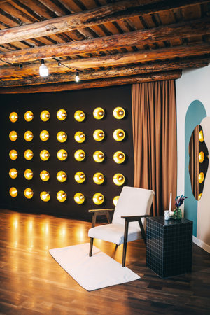 armchair with light fabric against of incandescent lamps. area with armchair and bright floor lampsの写真素材