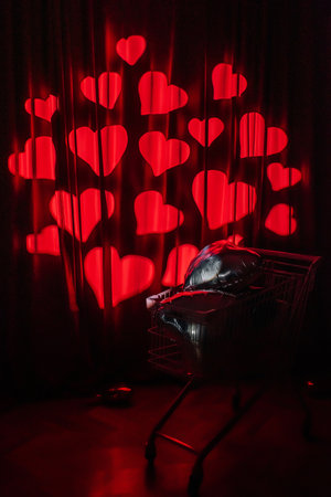 supermarket trolley full of foil balloons on red background. creative photo zone with heartsの写真素材