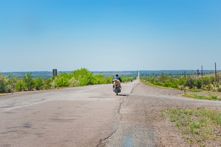 transporting livestock on a motorcycle. a man on a two-wheeled motor transports a ramの写真素材