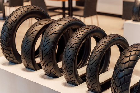 Motorcycle racing tire display in store. Black rubber tires for scooters on track