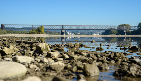 Landscape with a river, stones and a railway bridge. River Rhine in Germany.のeditorial素材