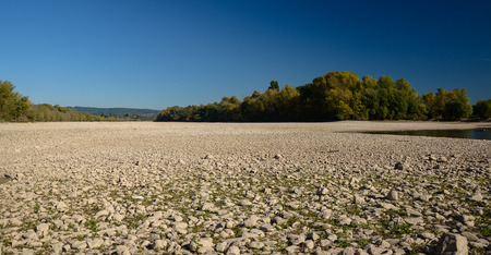 Dry riverbed on a nice autumn day with visible trees. River Rhine in Germany.の写真素材