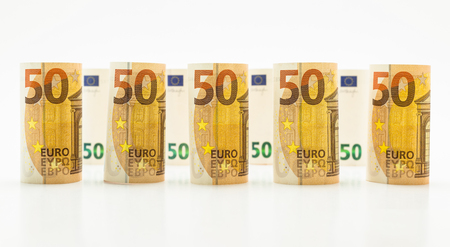 Rolled up 50 euro banknotes in rows. Isolated on a white background.の写真素材