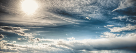 Cloudy, blue, rainy sky with clouds and sun. Colorful evening nature.