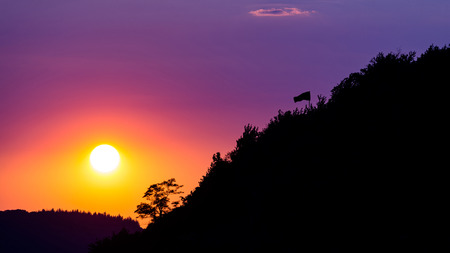 Beautiful purple sky in front of the sunset over the hills.の写真素材
