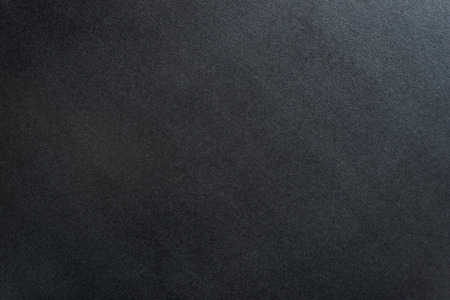 Black textured background with dim light from the right.