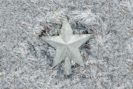 Silver stars lies on a silver tinsel background, christmas decorations.の写真素材