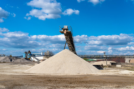Conveyor over heaps of gravel on an industrial cement plant.の写真素材