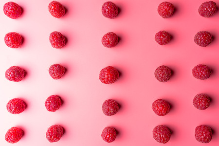 Pattern made from fresh raspberries, top view, flat lay pattern, isolated on a light pink background.の写真素材