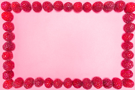 Frame made from fresh raspberries, top view, flat lay, isolated on a light background with copy...