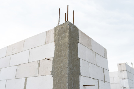 The walls of the house are built with white stones and are in the form of ribbed stones, wooden formwork.の写真素材