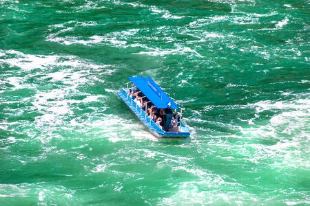Neuhausen am Rheinfall, Switzerland - 23 July 2019. Waterfall on the river Rhine in Neuhausen am Rheinfall, Schaffhausen in Switzerland. Boats carrying tourists on the river near the waterfall.のeditorial素材
