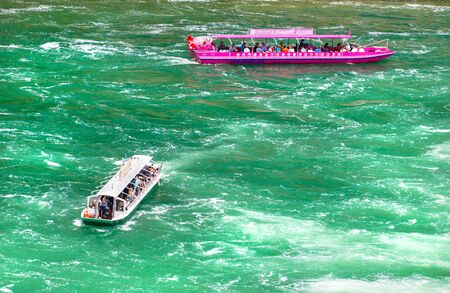 Neuhausen am Rheinfall, Switzerland - 23 July 2019. Waterfall on the river Rhine in Neuhausen am Rheinfall, Schaffhausen in Switzerland. Boats carrying tourists on the river near the waterfall.のeditorial素材