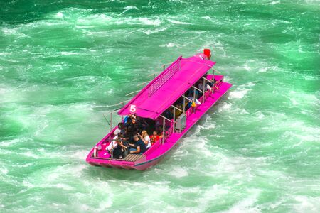 Neuhausen am Rheinfall, Switzerland - 23 July 2019. Waterfall on the river Rhine in Neuhausen am Rheinfall, Schaffhausen in Switzerland. Boats carrying tourists on the river near the waterfall.のeditorial素材