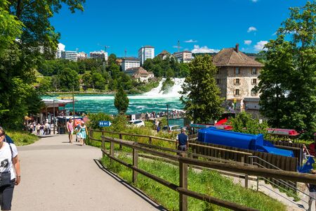 Neuhausen am Rheinfall, Switzerland - 23 July 2019. Waterfall on the river Rhine in the city of Neuhausen am Rheinfall in Switzerland. General view of the promenade and the waterfall.のeditorial素材