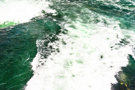 Background made from a rushing, foamy river in a beautiful turquoise and green color.の写真素材