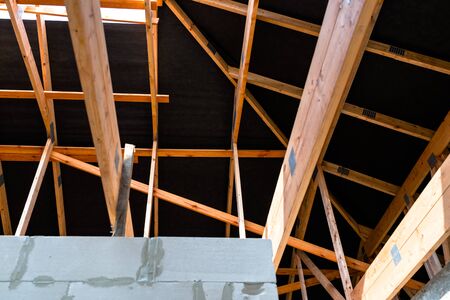 Roof trusses covered with a membrane on a detached house under construction, visible roof elements, battens, counter battens, rafters.の写真素材