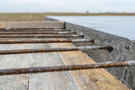 Reinforcing bars sticking out of reinforced concrete slab.の写真素材