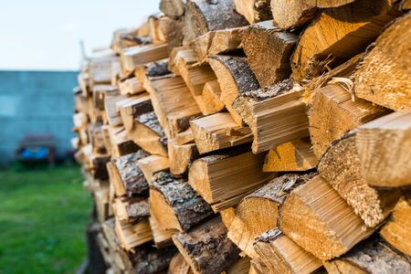 A pile of firewood stacked in a pile, cut trunks. Close up shot, wood background.