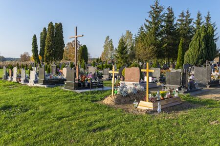 Cemetery with visible tombstones and crosses on a sunny day.