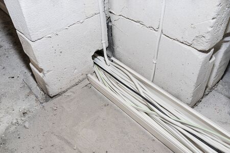 Layed installation of electric cables on the floor in a newly built house. Cables passing through...