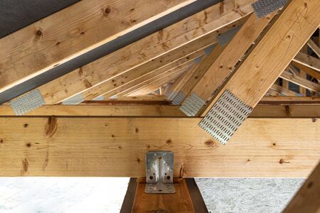 Roof trusses covered with a membrane on a detached house under construction, view from the inside,...