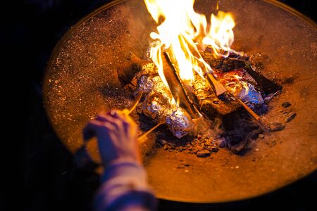 Potatoes wrapped in aluminum foil baked in a bonfire.