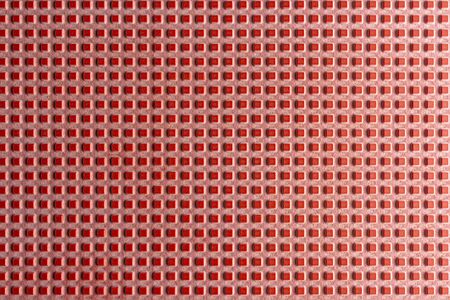 Real texture of pink rubber squares close up, illuminated with light.