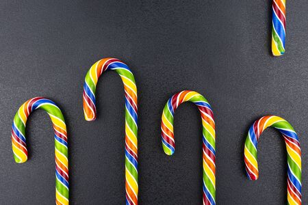 Background made of colorful candy canes, isolated on a black background.の写真素材